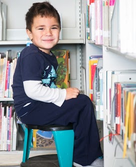 Student sitting on stool in library