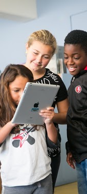 Three students looking at an iPad together