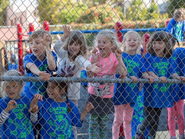 Children cheering each other on at an outdoor school fitness event