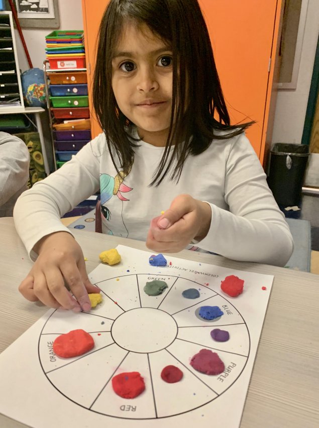 Child making color wheel with colored clay